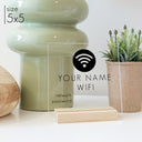 A 5x5 wifi password sign with a blonde stand on a kitchen counter